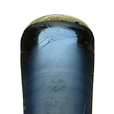 Figure 3. Curved banding as seen in a half boule of Verneuil synthetic corundum. Note that the curvature is greatest at the outside edges. Photo © Richard W. Hughes