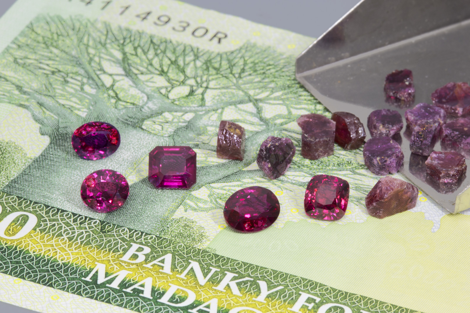 Faceted Madagasar rubies from the 2015 find, along with rough rubies from Moramanga collected by the author in 2005. The faceted stones are between 1.2 and 1.3 ct each. Photo: Wimon Manorotkul/Lotus Gemology.