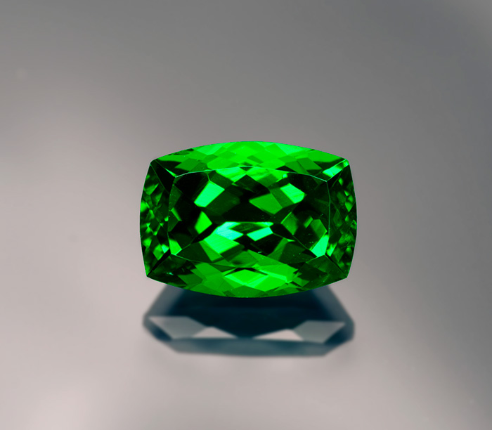 Figure 13. The color of this 7-ct tsavorite garnet is darker on the ends than in the center. This is not due to pleochroism—garnet is singly refractive—but an illustration of the Beer-Lambert law, where longer light paths result in greater absorption. Gem: Palagems.com; photo: Wimon Manorotkul 