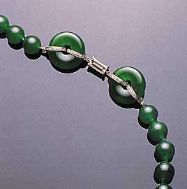 Figure 23. This necklace, which contains a total of 65 beads (7.8–9.8 mm in diameter) and two matching hoops, illustrates the optimum "vivid emerald green" color in fine jadeite. Note also the very fine "old mine" texture and translucency. Photo courtesy of and © Christie's Hong Kong and Tino Hammid.