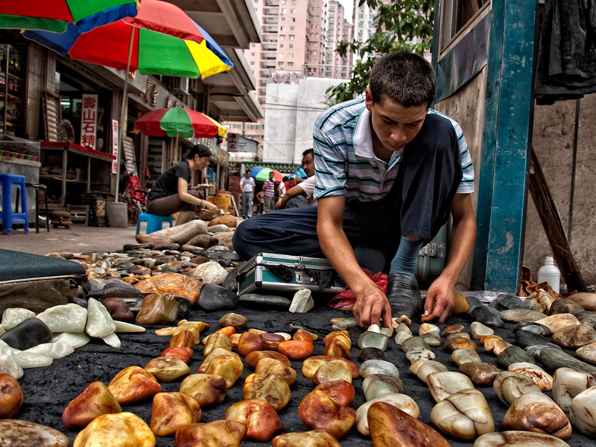 Figure 4. A Uighur man lays out his wares in Guangzhou's Hualin Street jade market. China's nephrite mines are located near Hotan (aka Khotan, Hetien), in western China's Xinjiang province. Photo: Richard W. Hughes.