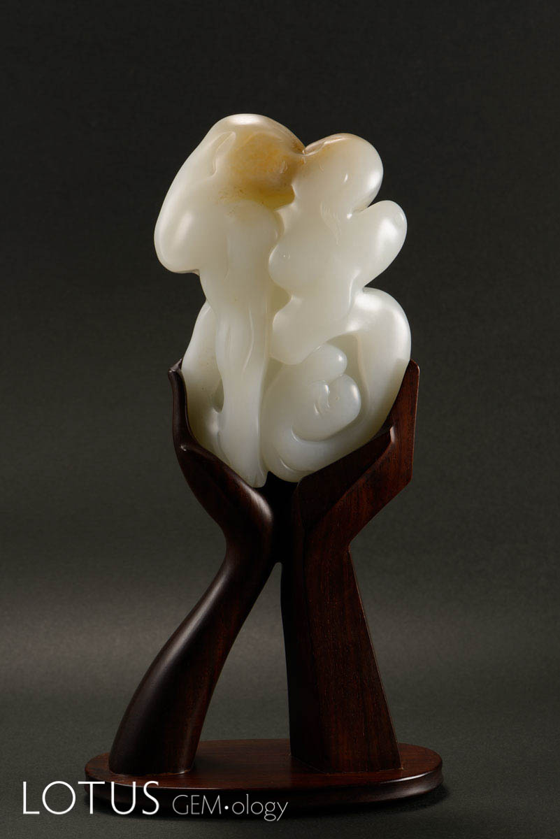 Blessing by Yu Jing. The front view is the Chinese character of "happiness" with a pattern culture. The pattern consists of a couple, in which the wife is pregnant with a child and expresses the happiest moment of a family. Hetian "mutton fat" nephrite from Xinjiang, China; 11.2 x 7.6 x 2.8 cm;1999. Photo: Zou Liu. Click on the photo for a larger image