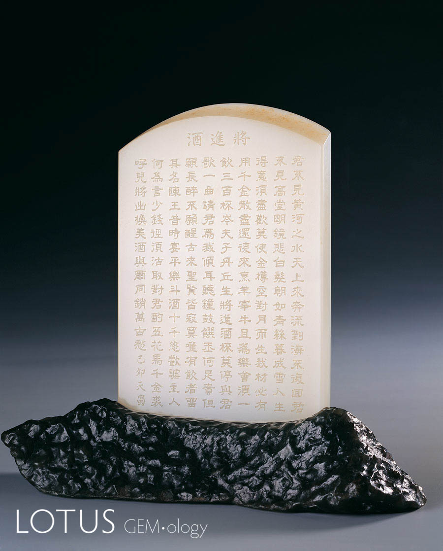 Chinese drinking song engraved on Hetian "mutton fat" nephrite jade sits atop a base of naturally weathered nephrite jade from the Gobi Desert. Carving by Yi Shaoyong. 7.7 x 11.6 x 1 cm; 1999. Photo: Zou Liu. Click on the photo for a larger image