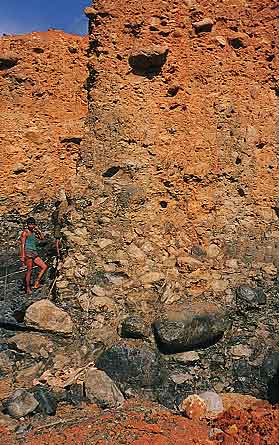Figure 4. At the Ka Htan West mine, located between Lonkin and Tawmaw, large peridotite boulders can be seen at the base of this 15-m-high wall of Uru Boulder Conglomerate. Photo © George Bosshart.