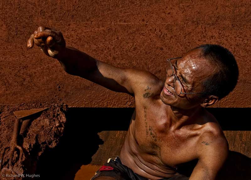 One of the last remaining sapphire miners at Khao Ploi Waen examines a find. Photo: Richard W. Hughes, February 2009.