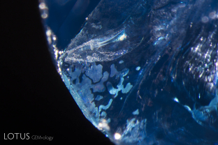 Many gems entering the market from Burma have been found to be oiled in an attempt to conceal their fissures. In transmitted light, the trapped air bubbles within the oil-filled fissures appear in high relief rounded patches. If the hot point is stroked against the surface, when the temperature is sufficiently raised, the trapped air bubbles will expand and contact as the hot point move closer or farther from them.
