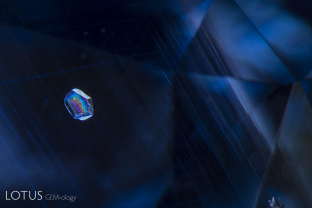 A euhedral birefringent crystal floats against a canvas of rutile silk in this untreated sapphire from Sri Lanka.
