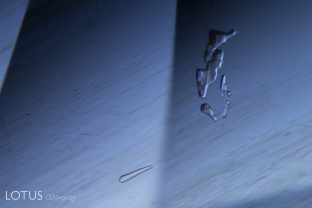 Irregular crystals float above exsolved rutile silk in this untreated sapphire from Sri Lanka.