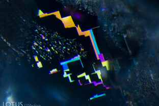 Fingerprints betray the underlying atomic symmetry. In this case, this iridescent fingerprint lies along a prism face, as demonstrated by its rectilinear form.