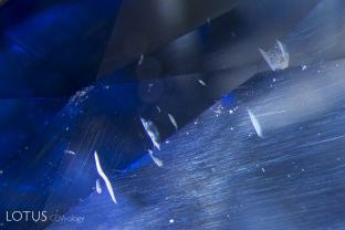 Many crystals contain shallow fissures on their surfaces. In sapphires from Sri Lanka, Myanmar and Madagascar, these fissures often contain yellow stains. High-temperature heating not only destroys the yellow stains, but begins a process of healing, where the fissures turn white and start forming fingerprints, as we can see here.