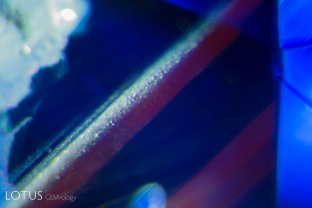 Yellow color zones in a heat-treated blue sapphire from Sri Lanka fluoresce red when illuminated with a fiber-optic light source.
