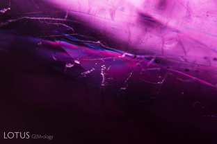 Flashes of color in glass-filled fissures betray the treated nature of this ruby.
