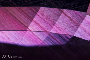 Sharp angular growth zoning in red bands lies against a backdrop of undissolved rutile silk in this purple sapphire from Sri Lanka.
