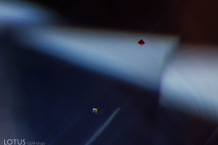 A tiny red uranium pyrochlore octahedron glows in this sapphire from Pailin, Cambodia. These pyrochlore crystals are a diagnostic inclusion for magmatic sapphires.