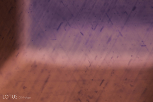 When a rutile-silk containing sapphire is heated, titanium from the rutile dissolves into the surrounding sapphire. Once in solid solution, the titanium reacts with iron, creating a blue color. The result is tiny blue halos surrounding the remnants of the rutile silk, a process dubbed “inkspot internal diffusion” by John Koivula. This partially dissolved silk with blue color concentrations is a clear sign that the sapphire was heated.