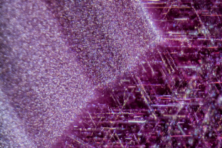 In Mozambique rubies, rutile silk typically occurs in different forms, and here we can see two. At left is a zoned cloud of fine particles, while on the right, well developed needles are seen.