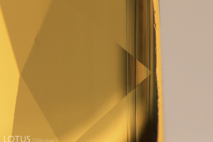 Thin layer of iron-rich silk in a yellow sapphire from Chanthaburi, Thailand. This type of silk is typically found in green layers on the skin of the crystal and thus after cutting, is generally found just under the table and/or culet.