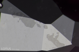 Patches of glass on the surface of a heat-treated ruby from the Thai/Cambodian border region.