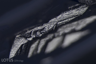 Etch marks of the surface of a natural on a sapphire from Myanmar’s Mogok Stone Tract. The symmetry of the etch marks reveals the underlying atomic symmetry.