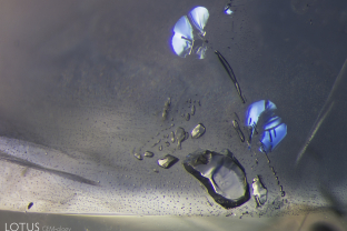 The surfaces of these negative crystals are glossy and smooth, showing signs of heating in this Sri Lankan sapphire.