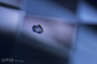 A slightly corroded crystal floats the blue sea of a Madagascar blue sapphire.