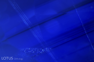 Streamers of small particles cross a sharp angular zoning pattern in this vivd blue sapphire from Madagascar.