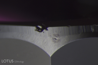 Laser-Induced-Breakdown-Spectroscopy (LIBS) is used by some gem labs to test for beryllium. Unlike Laser Ablation Inductively Coupled Plasma Mass Spectroscopy (LA-ICPMS), the surface is actually melted (rather than ablated), producing the circular rippled mark we see in the center of the girdle on this stone.