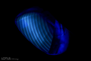 Curved banding is easily spotted in this flame-fusion blue synthetic sapphire when illuminated with the Magilabs deep-UV fluorescence system, a short-wave UV source.