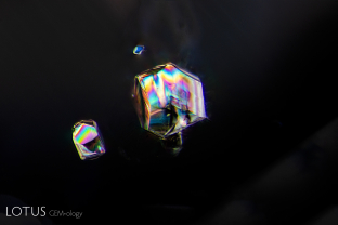 Crossed polars reveals in spectacular fashion the birefringent nature of these included crystal grains in this sapphire derived from a basaltic deposit.