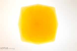 The lack of contrast when a yellow stone is viewed using a yellowish incandescent light makes it difficult to see the growth zoning.