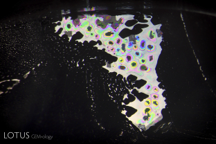 Photomicrography is no different than ordinary photography. It’s all about controlling light. In this case, a nondescript fluid inclusion in dark-field illumination morphed into a spectral spectacular when light was brought from above. 
