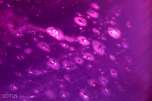 This ruby from Tajikistan contains many small crystals surrounded by rosette-like accretion halos.