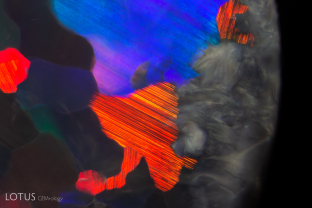 While the play-of-color effect is evident in this opal, on the right we can also see swirled grey potch.