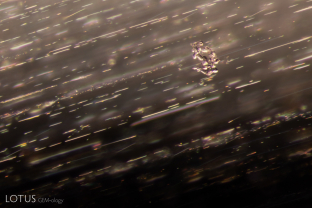 This untreated sapphire contains a cluster of small, transparent crystals appears to float amidst a cloud of fine silk needles.