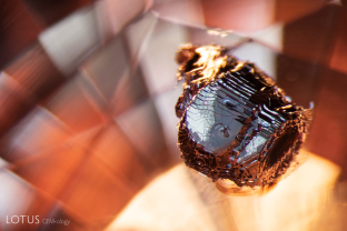 This large crystal is an interesting feature in its sapphire host thanks to the striking geometric growth pattern on its surface. It is likely that this is a sulphide crystal.
