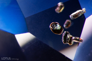 A group of brown crystals with lustrous surfaces are clustered together in this untreated sapphire.