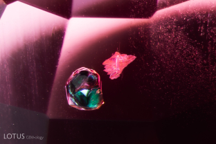 While testing this stone, this pair of crystals piqued our interest. Analysis with micro Raman identified the green crystal on the left as amphibole, and the crystal on the right as mica. A dusting of silk can also be seen in the background.