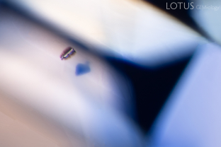 These two elongated zircon crystals appear to float above the deep blue color zones of this sapphire from Madagascar. The microfissures surrounding the crystals are a result of radiation from the thorium and uranium traces in the zircon.