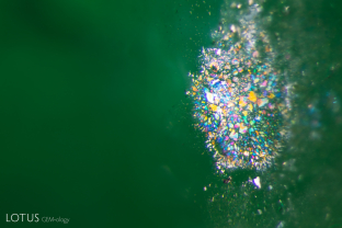 A Pollock-esque scene, in green. At high magnification, a cluster of iridescent thin films creates a burst of color in this Russian emerald.
