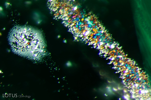 A bouquet of iridescent thin films can be observed in this emerald from Russia.