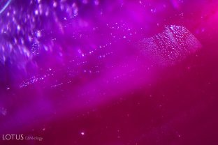 Fine streams of “rain-like” particles in a heated flux grown synthetic ruby.