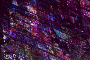 Iridescent fissures illuminate the interior of this ruby. These fissures typically form along the rhombohedron faces and result from external (secondary) pressures after the crystal formed. The same pressures produce polysynthetic glide twinning.