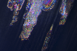 Meteor shower. The high temperature used when treating this blue sapphire from Myanmar (Burma) has resulted in some unusual iridescent fingerprints situated in the basal plane and aligned with the bands of partially dissolved silk remnants.