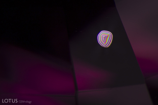 A transparent, birefringent crystal displays a technicolor bull’s eye pattern when viewed in crossed polars.