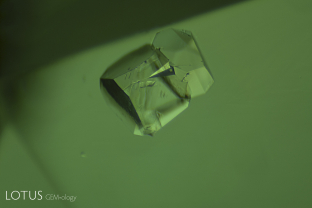 Twinned pyrite crystal in an emerald from Colombia. The formation of pyrite before emerald sucked iron from the hydrothermal fluid, allowing Colombian emeralds to crystallize in an iron-poor environment. This is one factor that contributed to the fine green color of the Colombian stone, when compared with emeralds from other sources.