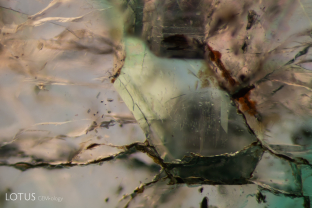 Emerald in emerald. A hexagonal core of emerald can be seen in the center of this larger emerald sample from Zambia. Note that the core also has its own inclusions of iridescent planes and fine needles. Specimen courtesy Gemfields.