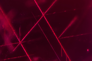 Rose channels are often confused with rutile silk in corundum, but they are easily distinguished as they run in entirely different crystallographic directions. Rutile silk unmixes in three intersecting directions (60/120°) parallel to the faces of the hexagonal prism in the plane of the basal pinacoid. In contrast, Rose channels form parallel to the edges of the rhombohedron, in three directions, but only two in the same place. They intersect at 86.1/93.9°. This ruby from Kiteto, Tanzania shows nice examples.