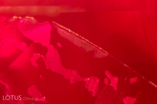 Flattened gas bubbles within a glass-filled fissure of a treated Mozambique ruby.
