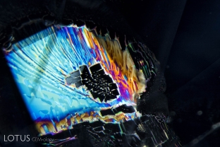 A brilliantly iridescent fingerprint in a sapphire from Sri Lanka. Such healing patterns reveal the underlying atomic symmetry. In this case, the rectangular healing pattern shows that this fingerprint lies parallel to a prism face.