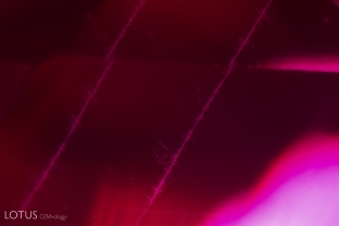 Strings of fine exsolved particles and needles form in lines across this unheated ruby from Tajikistan.